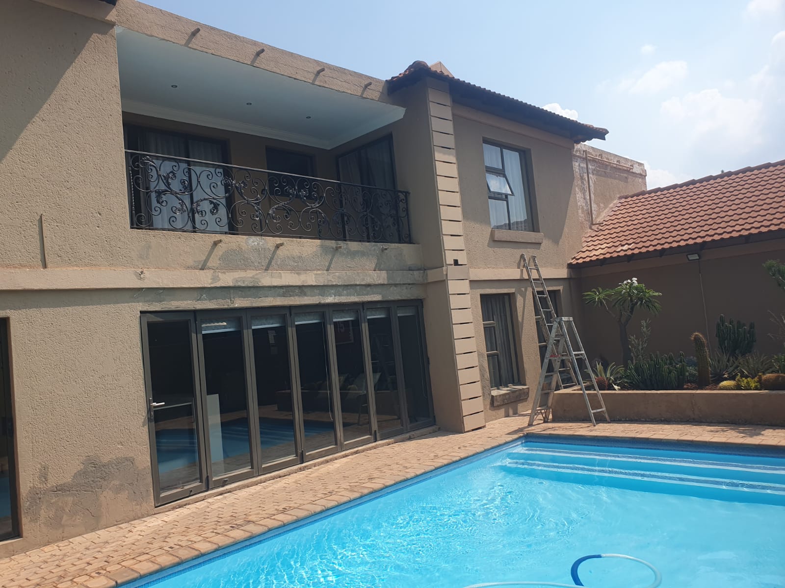 Exterior house painting and renovation next to a swimming pool in Pretoria by C.M Construction
